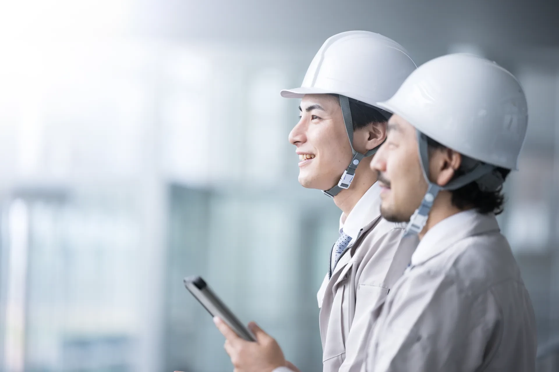 先輩と並んでタブレットを見ながら現場を確認する若手社員