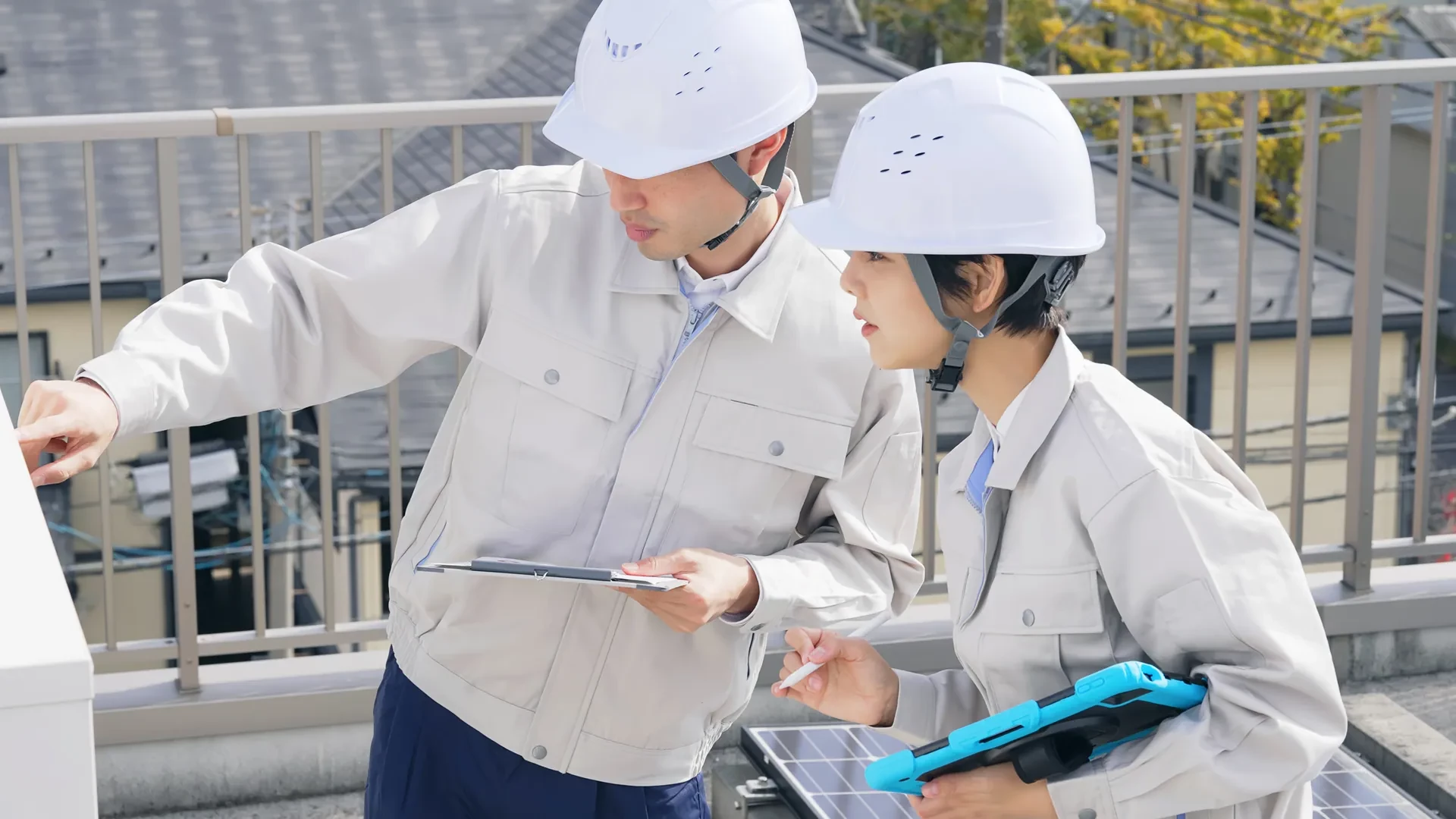 屋上で後輩に作業を教える先輩社員