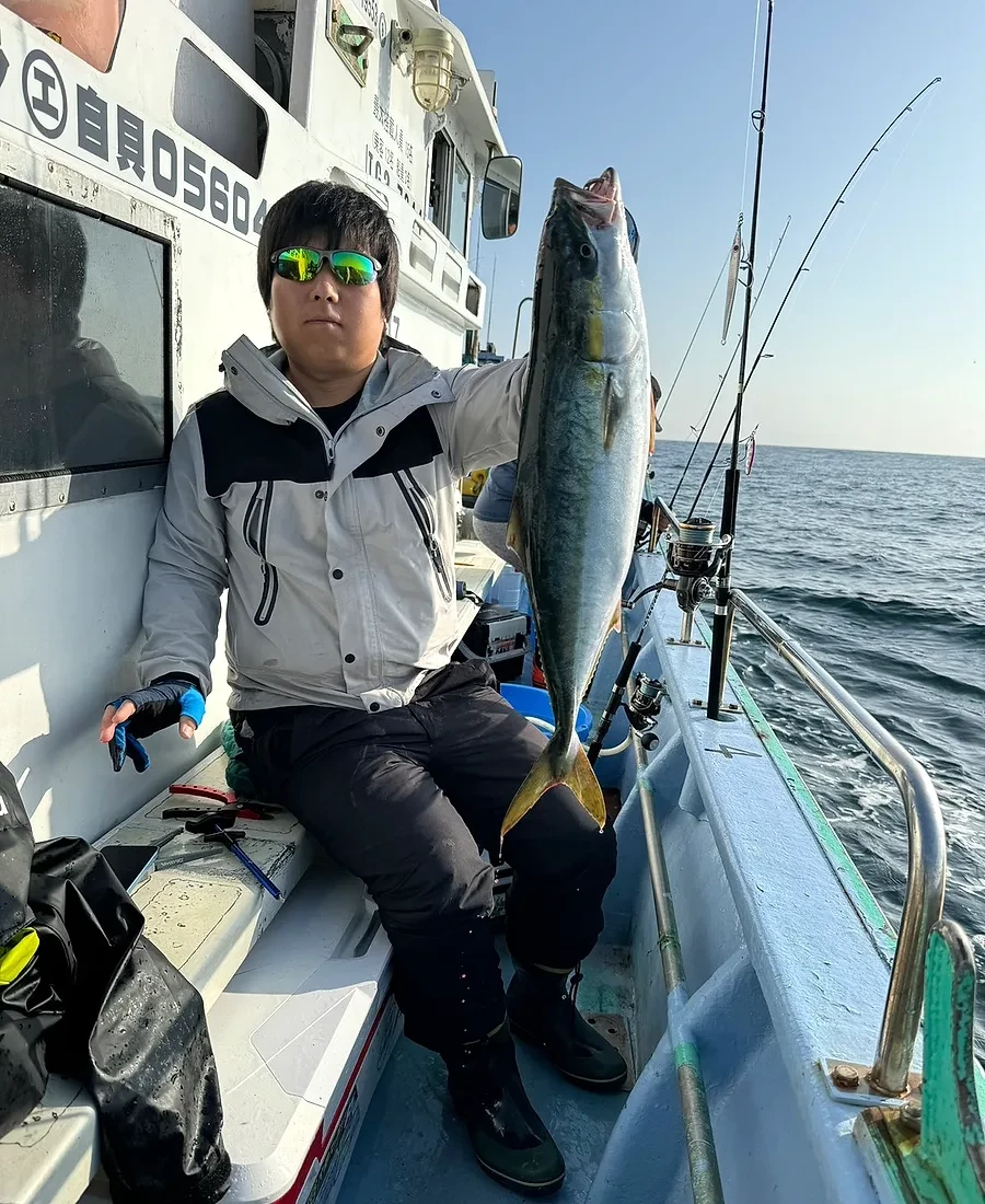 釣り上げた魚を手にするKENSINのスタッフ