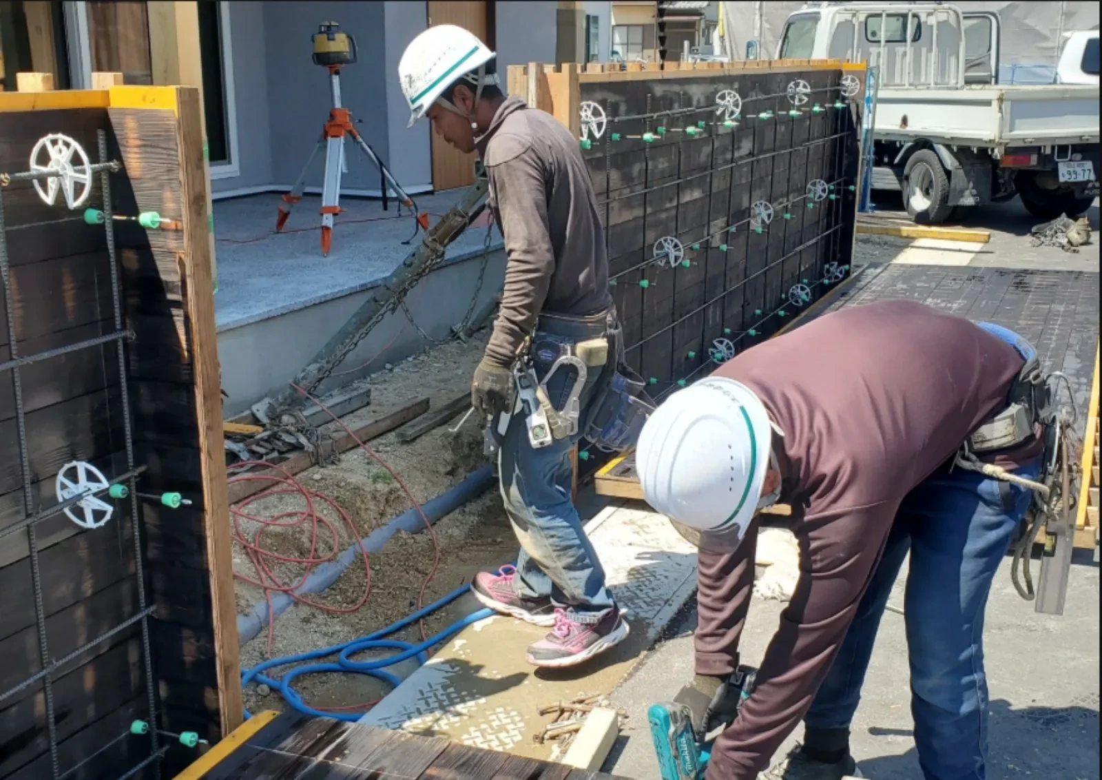 住宅基礎の型枠を建て込む職人2名