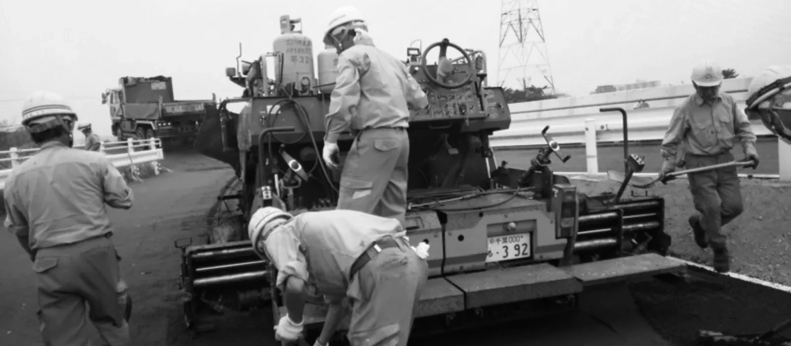 複数の職人と重機が並ぶ施工現場