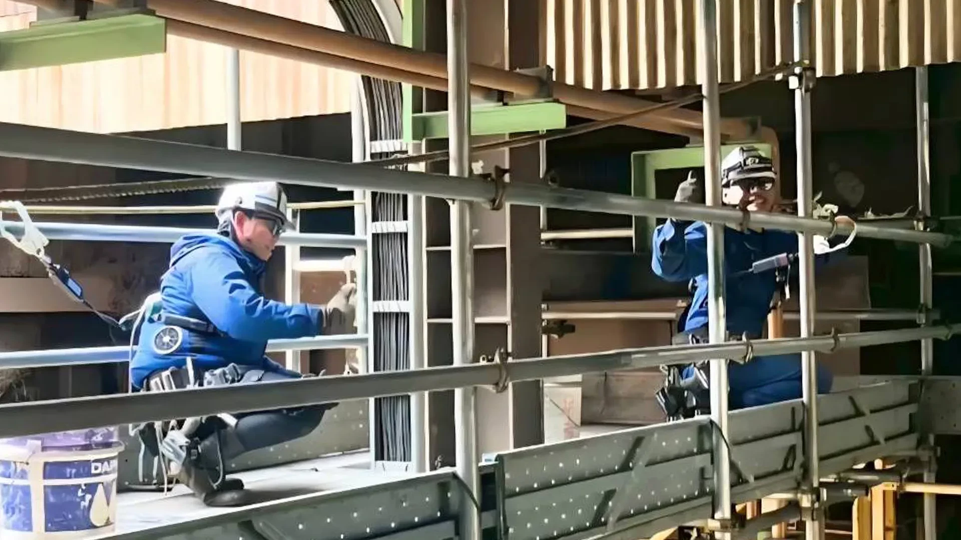 足場上で一緒に作業する社員
