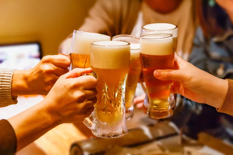 同僚同士でビールを手に乾杯する様子