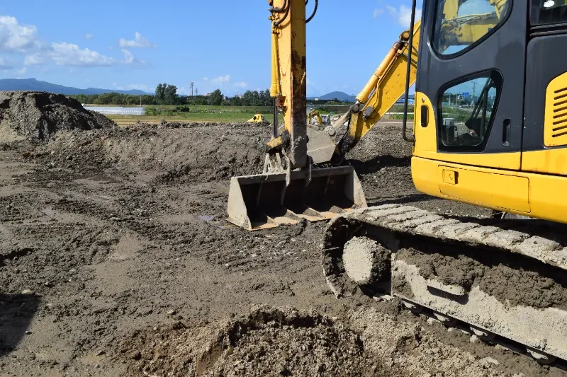 造成現場で稼働する油圧ショベル