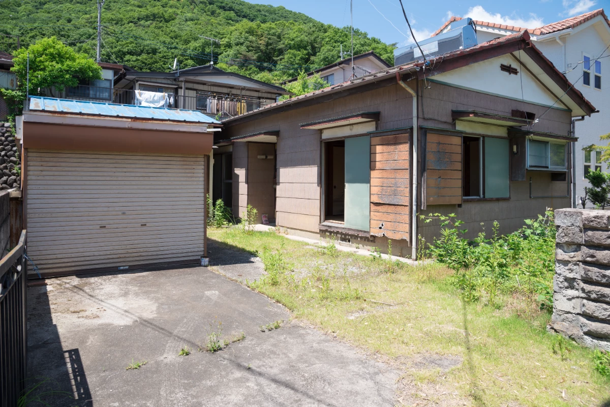 草が伸び、傷んだ建物まわりの敷地（施工前）