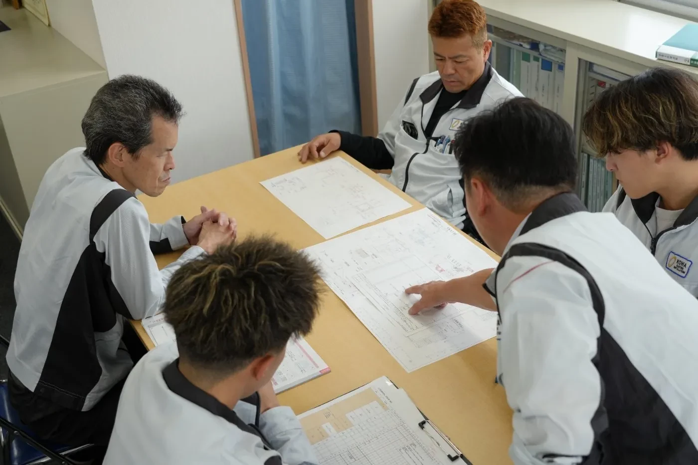 先輩と若手が並ぶ打ち合わせの様子