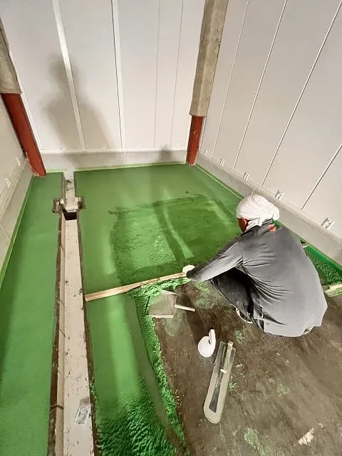 床にしゃがんで作業する職人