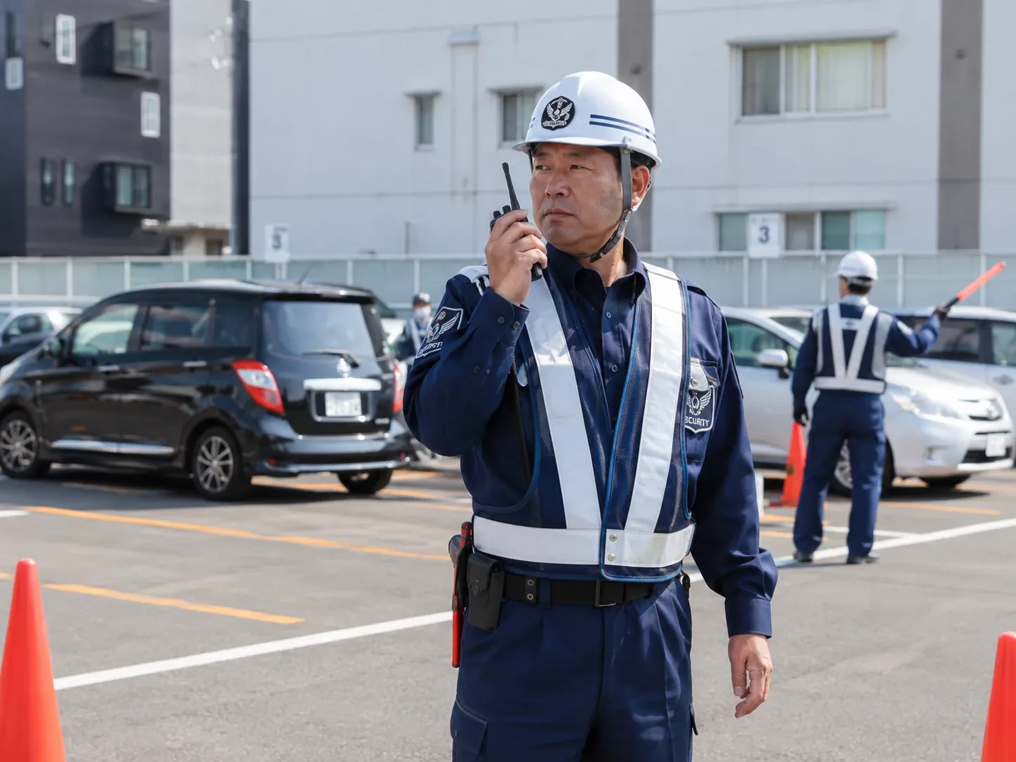 無線で連絡を取る交通誘導警備員