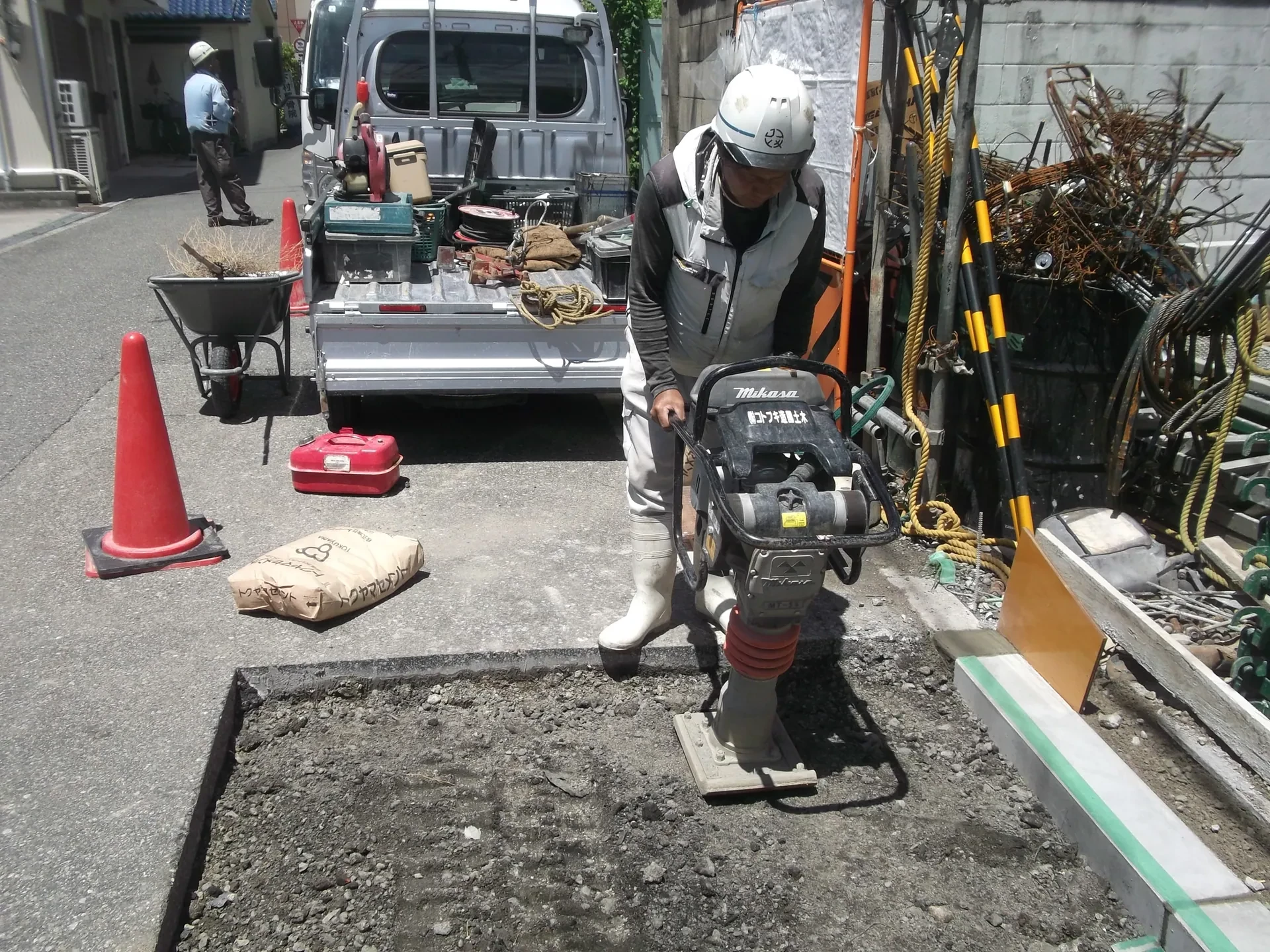 ランマーで地面を締め固める作業