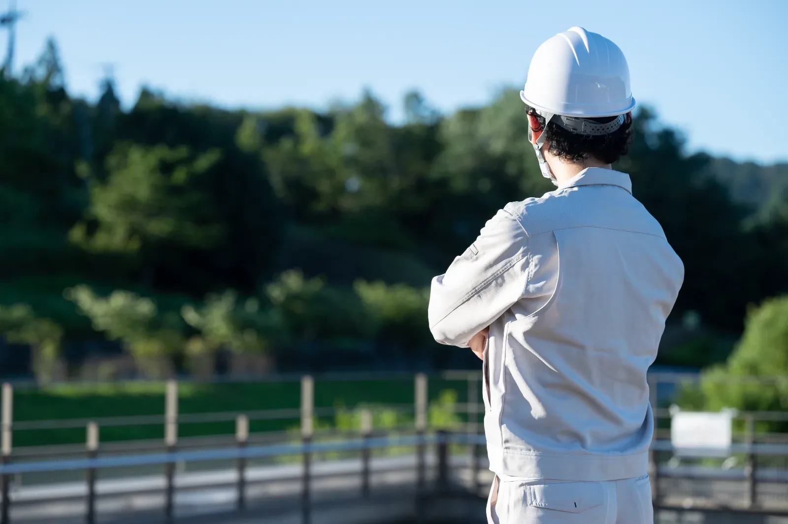 ヘルメットをかぶった作業員が現場を見つめているようす