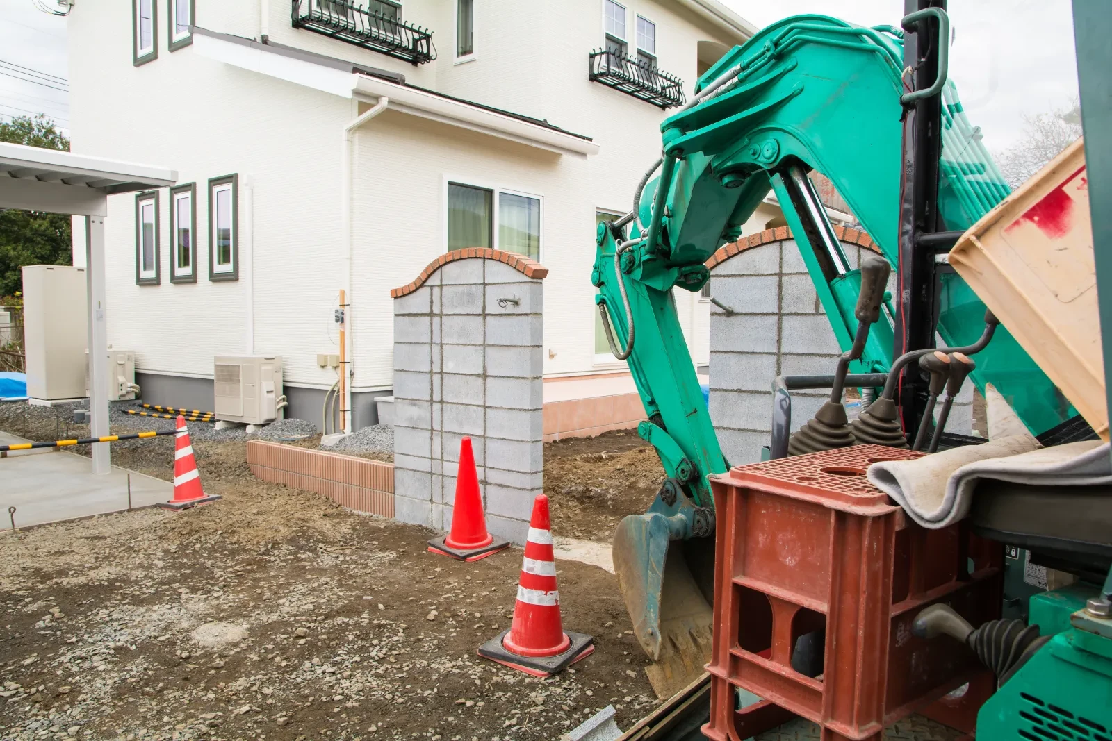 住宅の門と駐車場まわりを仕上げている外構工事の現場