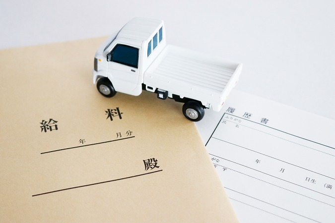 給与の封筒とトラックのおもちゃ