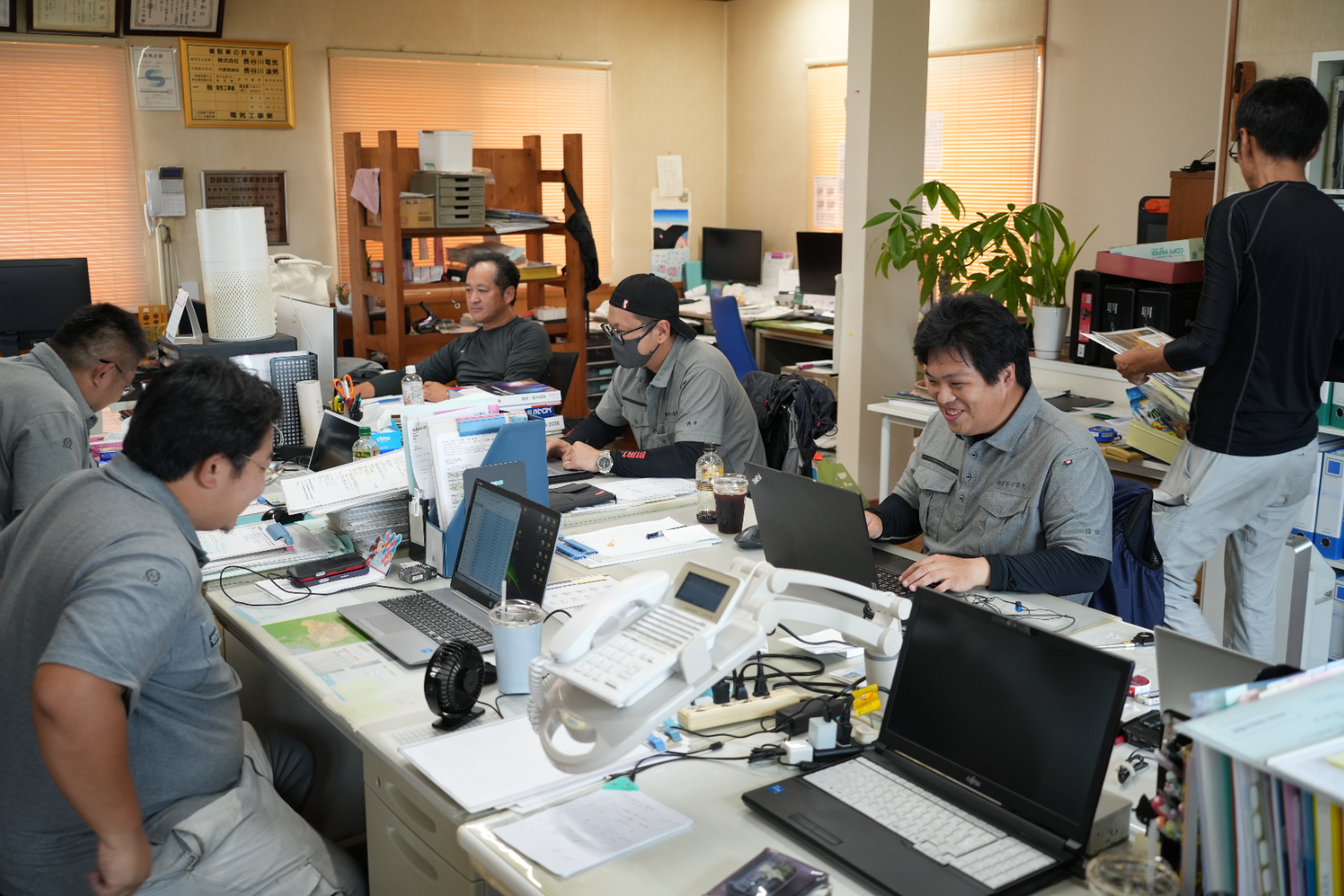 事務所で打ち合わせをするスタッフ
