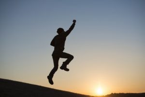 ジャンプする人と夕日