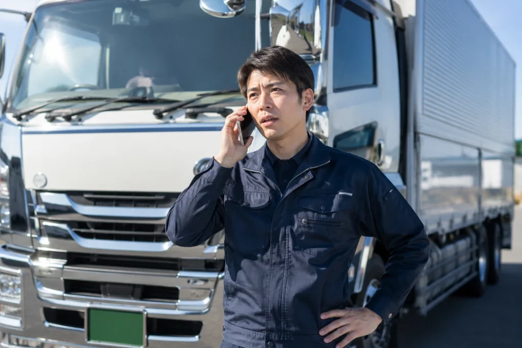 事務所で電話対応する配車担当