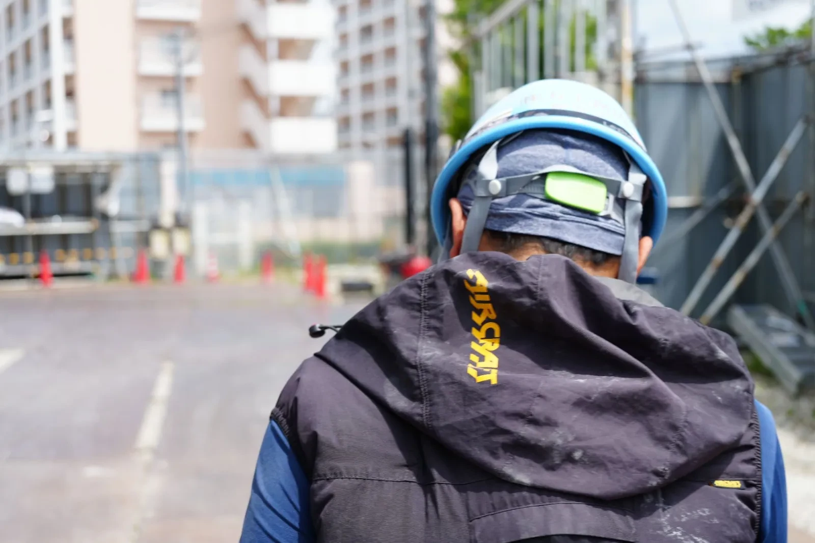 ヘルメットをかぶり、現場へと続く通路を歩いていく創墨社スタッフの後ろ姿