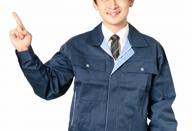 指を立てる作業着の男性